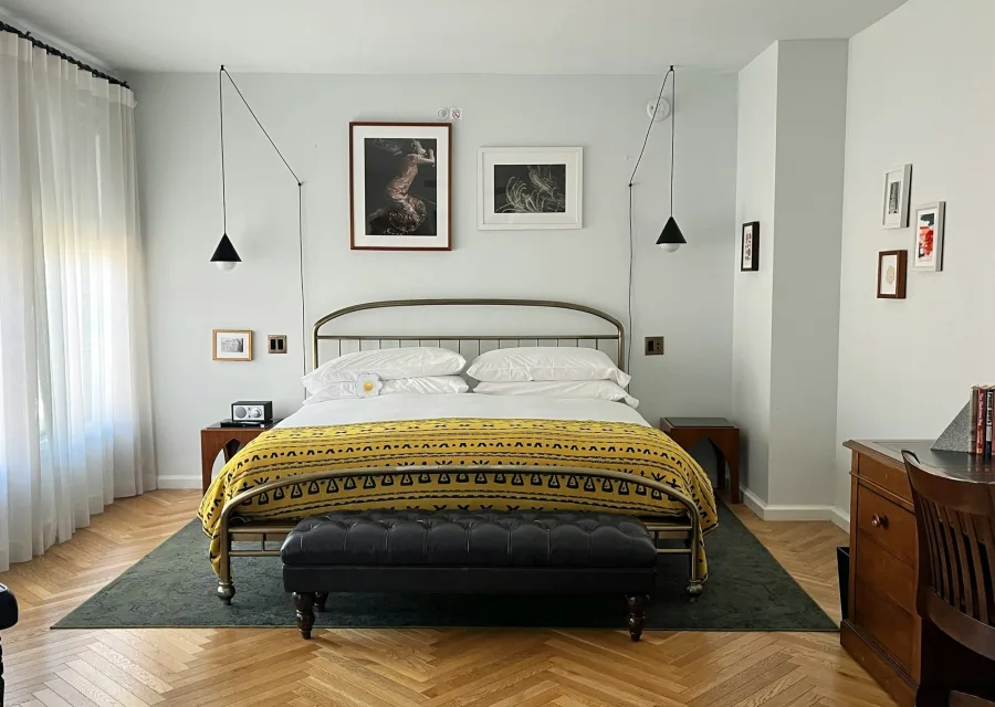 Chambre L'Estran : lit en métal, parquet, lumière du matin
